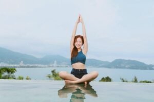 Woman doing yoga by the pool.